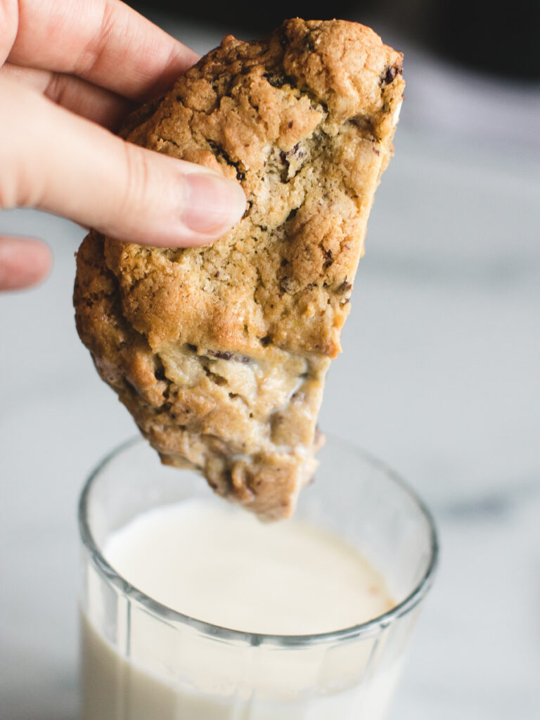 Kitchen sink cookie dipped in a glass of milk.