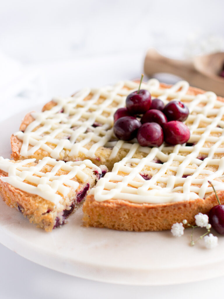 Almond cherry cake slice showing delicious cherries inside.