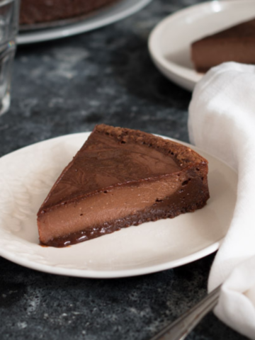 Chocolate cheesecake brownie cut into a triangle slice.