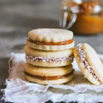 Classic alfajores filled with dulce de leche and rolled in shredded coconut | rosechocolatier.com