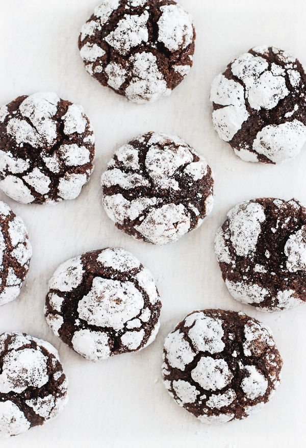 Beautiful chocolate crinkle cookies are coated with powdered sugar to reveal cracks and crinkles on the outside of the cookie.