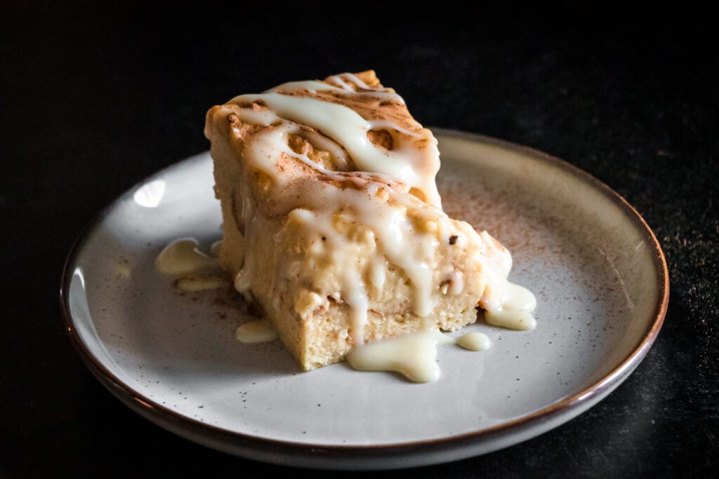 tres leches bread pudding topped with cinnamon and sweetened condensed milk