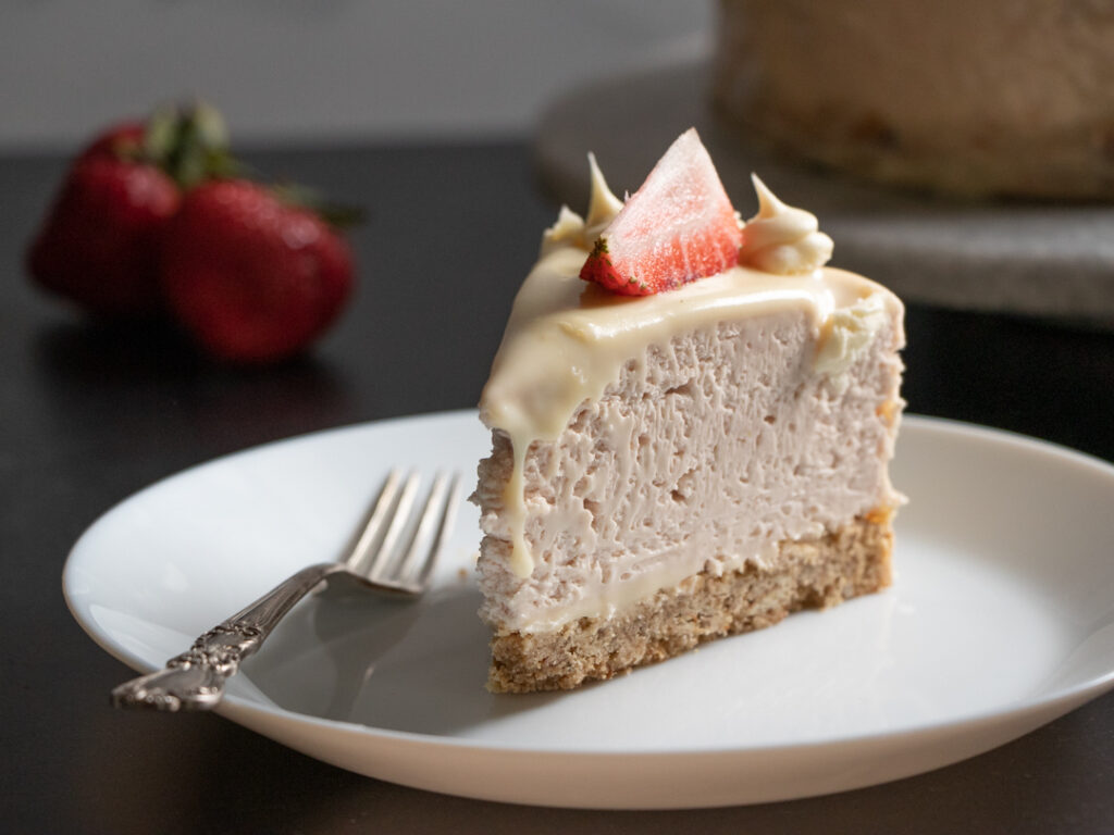 slice of strawberry cheesecake with white chocolate ganache and fresh strawberries, pretzel crust