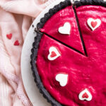 Raspberry curd tart with black cocoa crust, topped with panna cotta cream hearts.