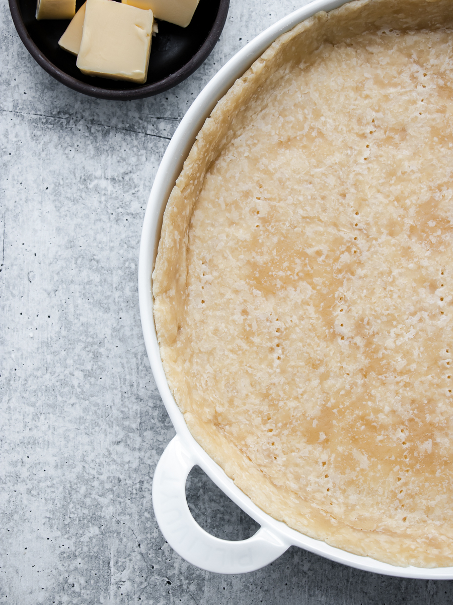 Closeup image of quiche crust partially baked.