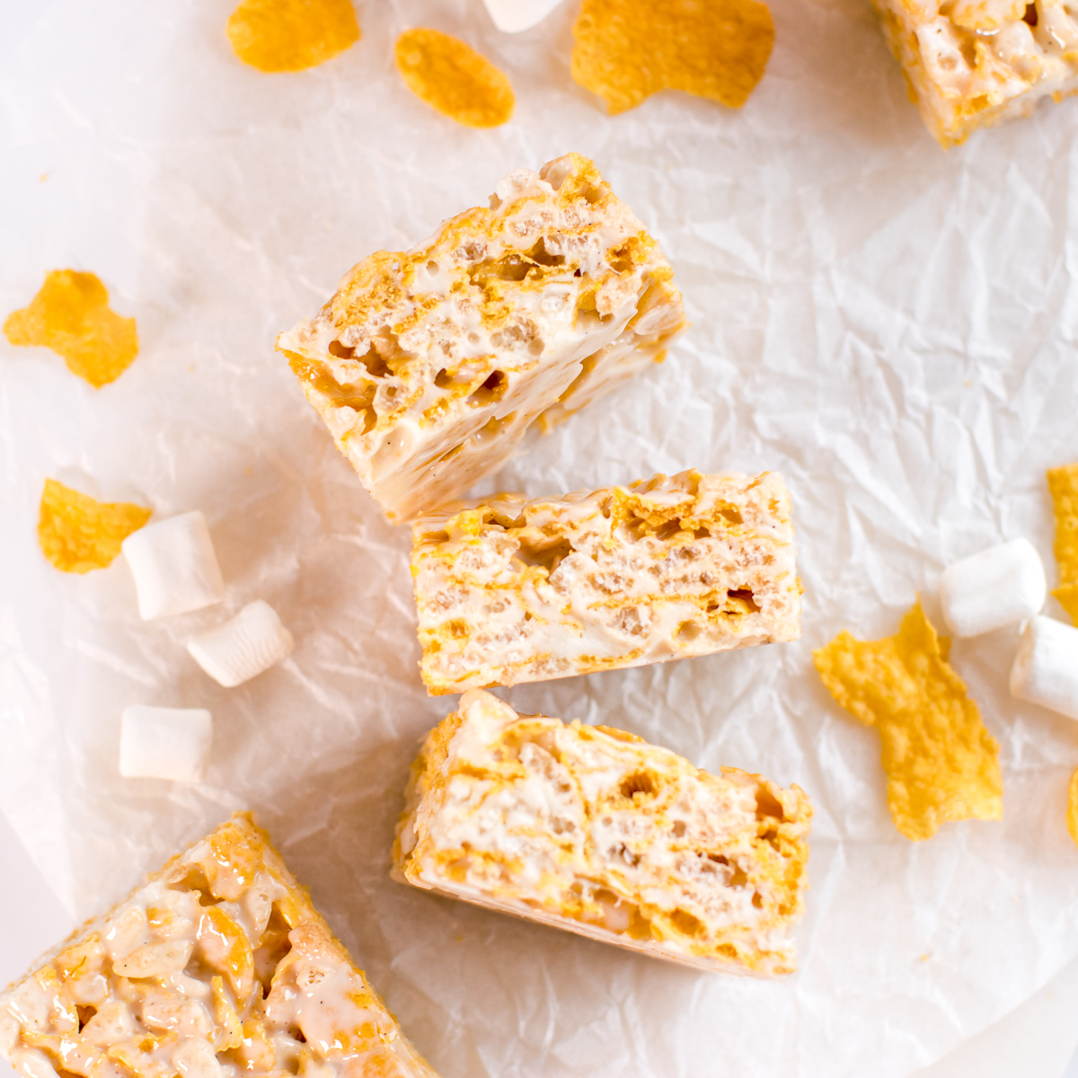 Cornflake marshmallow treats cereal bars with corn flakes and marshmallows scattered.