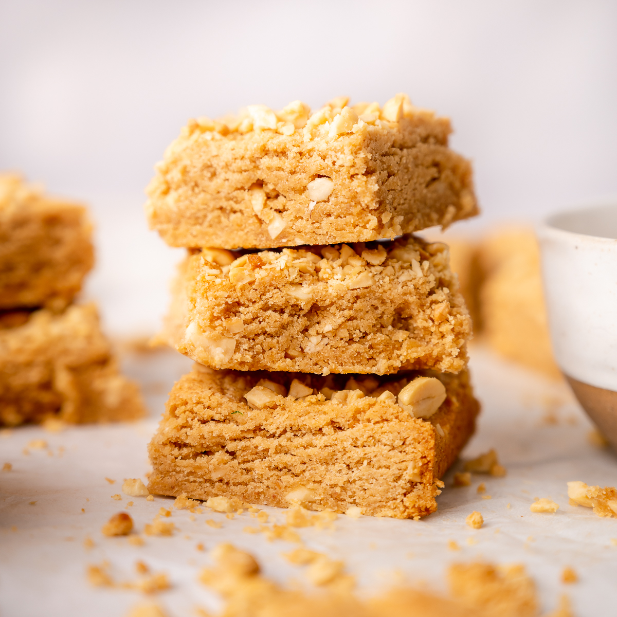 Small stock of peanut butter blondie bars with chopped peanuts on top.