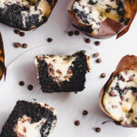 The most delicious Black bottom cupcakes cut in half to reveal the cheesecake centers with mini chocolate chips.