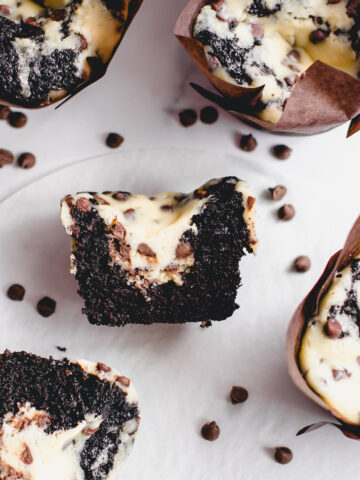 The most delicious Black bottom cupcakes cut in half to reveal the cheesecake centers with mini chocolate chips.