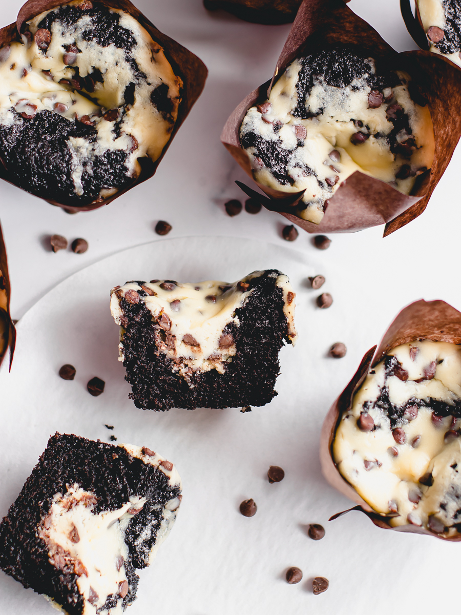 The most delicious Black bottom muffins or cupcakes cut in half to reveal the cheesecake centers with mini chocolate chips.