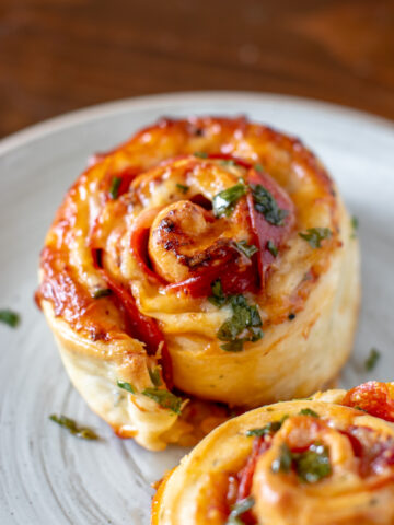 Cheesy garlic pepperoni pizza rolls baked and coated in garlic and herb.